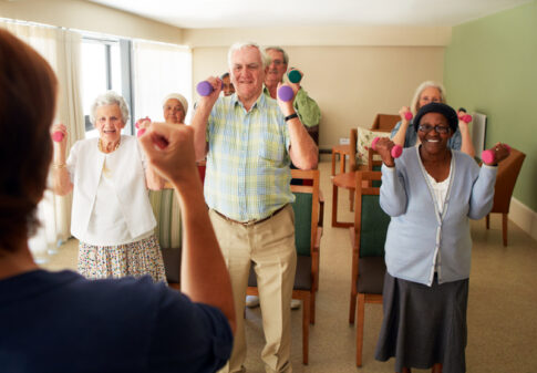 group of seniors enjoying fitness class with weights
