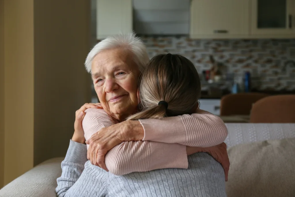 Senior woman embracing caregiver